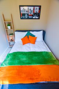 a bed with an orange and green blanket on it at Christine Apartment close to the Buda Castle in Budapest
