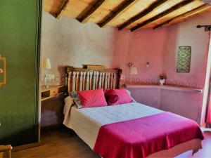 a bedroom with a large bed with pink sheets at Casa Zambrana in Pinofranqueado