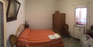 een slaapkamer met een bed, een tv en een raam bij Casa Vacanze Tursi in Tursi