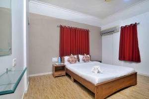 a bedroom with a bed and a red curtain at ShreeVilla Corporate Guest House in Nashik