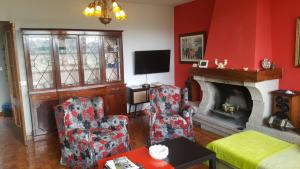 a living room with two chairs and a fireplace at Casa de Sabela in Culleredo