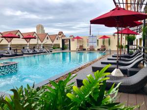 a pool at a hotel with chairs and umbrellas at Golden Sea Pattaya in Pattaya