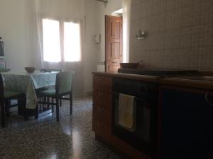 een keuken met een tafel, een wastafel en een fornuis bij Casa Vacanze Tursi in Tursi