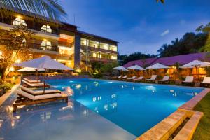 a swimming pool in front of a hotel at night at Azura Resort in Phu Quoc