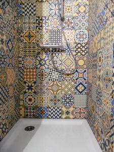 Baño con azulejos de colores en la pared en L'école buissonnière, en Combrand