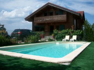 a swimming pool in front of a house at Chalet Les Aigles in Saint-Sixt