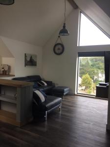 a living room with a couch and a large window at Tianavaig View Apartments in Portree