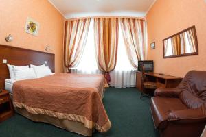 um quarto de hotel com uma cama e uma cadeira em Empire Park Hotel em São Petersburgo