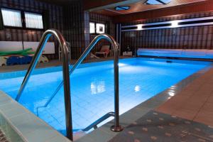 a large swimming pool with metal railings in a building at Haus Kanne in Bad Driburg