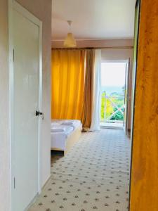 a bedroom with a bed and a large window at Palm Hotel in Novy Afon