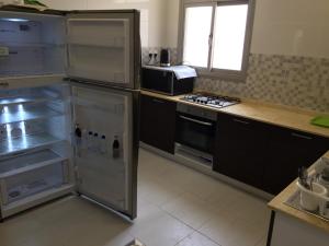a kitchen with an open refrigerator and a microwave at The Diamonds (Families Only ) in Al Khīrān