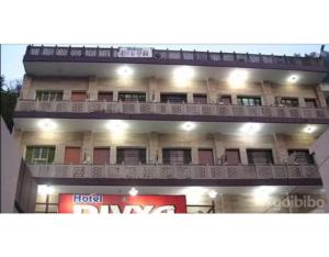 a hotel dmg with a balcony in front of it at Hotel Divya in Rishīkesh