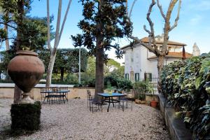 a garden area with a table, chairs, and a tree at Domus Monamì Luxury Suites in Rome