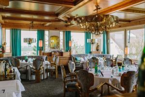 a dining room with tables and chairs and a chandelier at Hotel Schönbuch in Pliezhausen