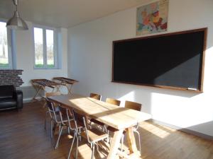 comedor con mesa y TV de pantalla plana en L'école buissonnière, en Combrand