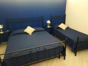 twee bedden in een slaapkamer met blauwe muren bij U dammusu ra cianta in Modica