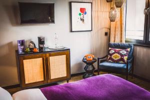 a living room with a purple rug and a chair at HENRI Hotel Düsseldorf in Düsseldorf