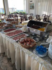 a buffet with meat and eggs on a table at Hotel Eden in Bellaria-Igea Marina +25 photos