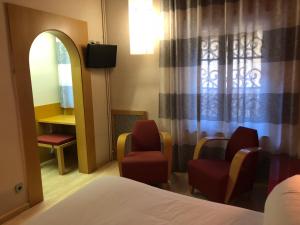 a room with a bed and two chairs and a mirror at Hostal de la Gloria in Viladrau