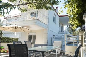 a patio with a table and chairs in front of a building at Nektarios Garenias Kipoupoli in Nea Kalikratia