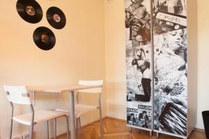 a table and chairs in a room with records on the wall at La Guitarra Hostel Gdańsk in Gdańsk