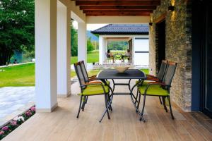 a patio with a table and chairs on a porch at Holiday home Green coast in Bosanska Krupa