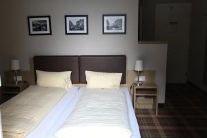 ein großes Bett mit zwei Kissen und zwei Nachttischen in der Unterkunft Hotel Staubbach in Lauterbrunnen