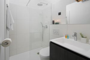 a white bathroom with a toilet and a shower at Apartment Fianona - Rovinj city center in Rovinj