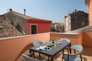 a table and chairs on the balcony of a building at Apartment Fianona - Rovinj city center in Rovinj