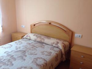 - une chambre avec un lit et une tête de lit en bois dans l'établissement Chalet en el Monte con Piscina, à Sagonte