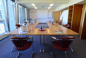una gran sala de conferencias con una mesa larga y sillas en Waldsee Golf-Resort, en Bad Waldsee