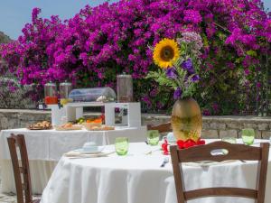 una mesa con un girasol con flores púrpuras en Agriturismo Margione, en Módica 26 fotos más