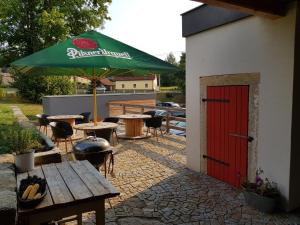 a patio with a red door and a table and umbrella at Penzion Only in Kunějov