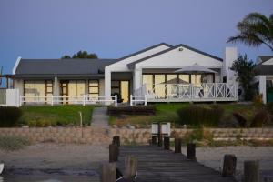 a house on the beach with a boardwalk at Rivertides Self Catering Guest House in Velddrif