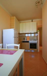 a kitchen with a white refrigerator and white cabinets at Backpackers Fairytale Hostel in Split