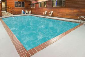 einen großen Pool mit blauem Wasser und Stühlen in der Unterkunft Super 8 by Wyndham Baker City in Baker City