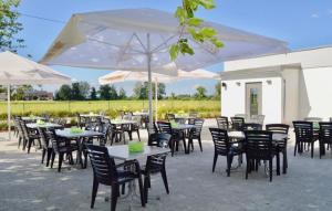 a group of tables and chairs with white umbrellas at Gästehaus Gaumenflug am See in Günzburg