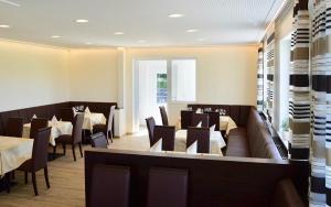 a dining room with tables and chairs in a restaurant at Gästehaus Gaumenflug am See in Günzburg