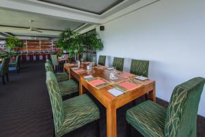 Un comedor con mesa y sillas de madera. en Kandy The Tourmaline, en Kandy