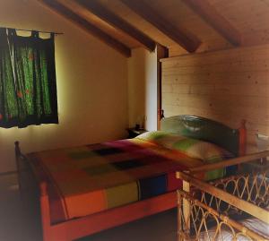a bedroom with a bed with a wooden head board at Il Casotto in Telve