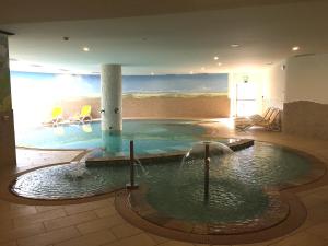 una piscina in una stanza con un dipinto sul muro di Hotel Stella Montis a Campitello di Fassa
