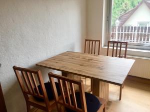 einen Holztisch und Stühle in einem Zimmer mit Fenster in der Unterkunft Private Wohnung in Leoben