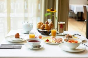 a table with breakfast foods and drinks on it at Sternen Hotel Wolfurt in Bregenz