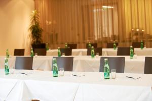 a room with white tables with green bottles on them at Sternen Hotel Wolfurt in Bregenz