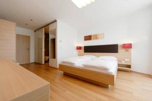 a bedroom with a bed with white sheets and a television at Sternen Hotel Wolfurt in Bregenz