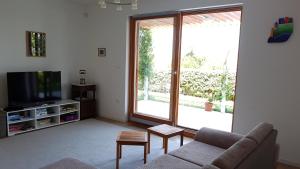salon z kanapą i telewizorem w obiekcie Apartman Di w miejscowości Mali Lošinj