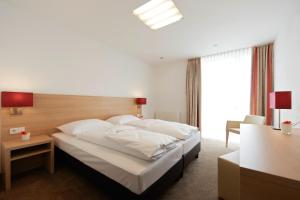 a bedroom with a large bed with white pillows at Sternen Hotel Wolfurt in Bregenz
