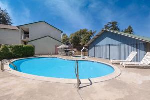 - une piscine avec 2 chaises et une maison dans l'établissement Creekside Inn & Suites, à Willits