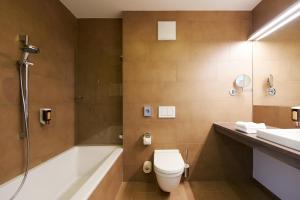 a bathroom with a shower and a toilet and a sink at Sternen Hotel Wolfurt in Bregenz