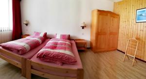 1 dormitorio con 1 cama grande con sábanas rosas en Apartmenthaus Sunshine, en Saas-Grund